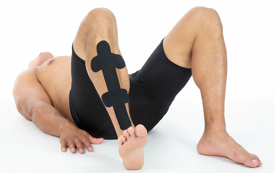 Man laying on the floor with kinesio tape on his shin 880x550 1